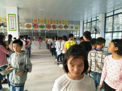 图为2017年建成标准化食堂的祁阳七中学生正有序打取各自所需的菜品
